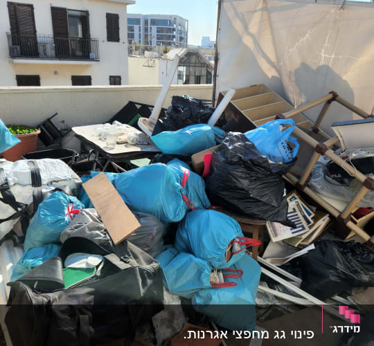 שקיות אשפה כחולות ושחורות על גג עם חפצים שונים